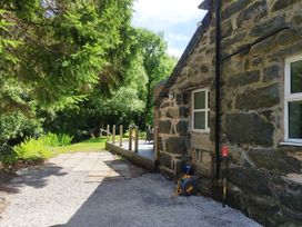An outdoor area with a stone wall and decking at Islwyn near Bala