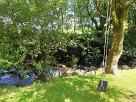 A swing hanging from a tree beside a stream at Islwyn in Llanuwchllyn near Bala