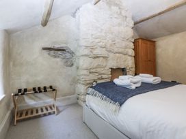 A bedroom with a bed and wooden cabinet at Islwyn Llanuwchllyn near Bala