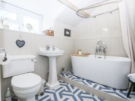 A bathroom with a bathtub, toilet, and sink at Islwyn near Bala
