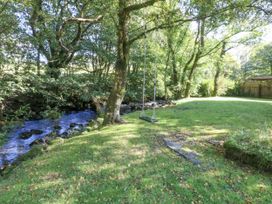 A garden with a swing and a stream at Islwyn Llanuwchllyn near Bala