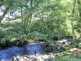 A stream flowing through trees and rocks at Islwyn in Llanuwchllyn near Bala