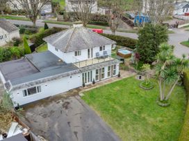 A two-story house with a balcony driveway and garden with trees at Broadsands in Paignton