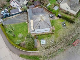 An aerial view of a house with a garden lawn lounge chairs a patio table and driveway Broadsands Paignton