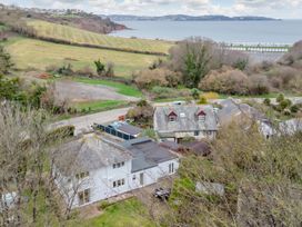 A coastal view with houses, trees, fields, a road, and the sea in the background at Broadsands Paignton