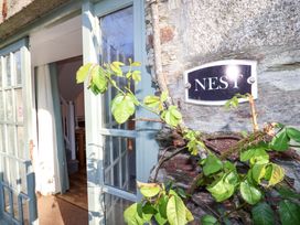 An entryway with a door and a sign at Nest Cottage in St Tudy