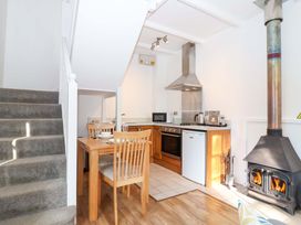 A kitchen with a dining table and chairs at Nest Cottage in St Tudy