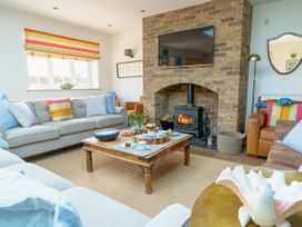 A living room with a fireplace and sofa at Y Graiglwyd Bull Bay near Amlwch
