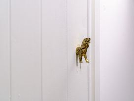 A decorative door knob in the shape of a dog on a white wall at Y Graiglwyd Bull Bay near Amlwch