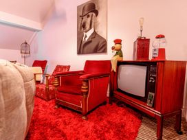 A living room with armchair and television at Y Graiglwyd Bull Bay near Amlwch