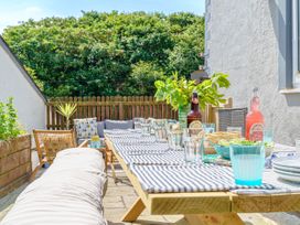 An outdoor sitting area with a table set for a meal at Y Graiglwyd Bull Bay near Amlwch