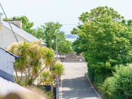 A view of a road with trees and buildings at Y Graiglwyd Bull Bay near Amlwch