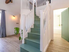 A hallway with a staircase and a door at Cwtch in Mold