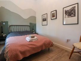 A bedroom with a bed and pictures on the wall at Cwtch in Mold
