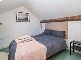 A bedroom with a bed and a picture hanging on the wall at Cwtch in Mold