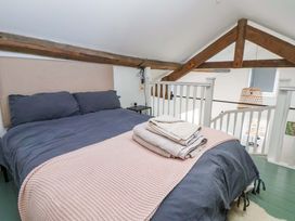 A bedroom with a bed and stairs at Cwtch in Mold