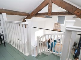 A staircase with white railing and wooden beams at Cwtch in Mold