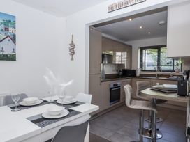 A kitchen with dining table and chairs at Driftwood in Torquay