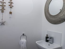 A bathroom with a washbasin and mirror at Driftwood in Torquay
