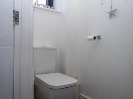 A bathroom with a toilet and toilet paper at Driftwood in Torquay