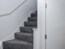 A staircase with carpeted steps and a white door at Driftwood in Torquay