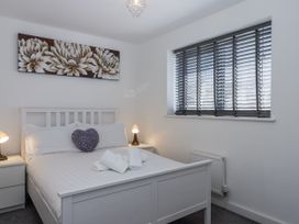A bedroom with a bed and bedside tables at Driftwood in Torquay