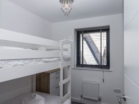 A bedroom with a bunk bed and a window at Driftwood in Torquay