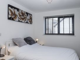 A bedroom with a bed and wall art at Driftwood in Torquay