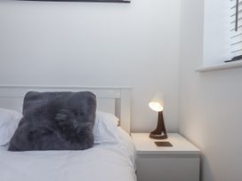 A bedroom with a bed and bedside table at Driftwood in Torquay