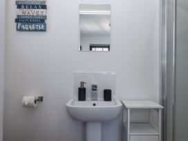 A bathroom with sink and mirror at Driftwood in Torquay