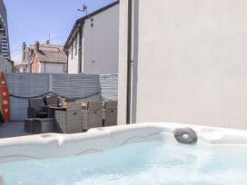 An outdoor area with a hot tub and seating at Driftwood in Torquay