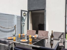 An outdoor dining area with a table and chairs at Driftwood in Torquay