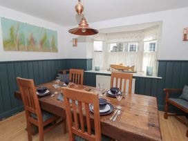 A dining room with a wooden table and chairs at Awen Ingli in Newport, Pembrokeshire