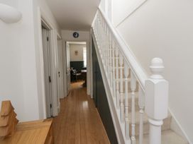 A hallway with a staircase and doors at Awen Ingli in Newport, Pembrokeshire