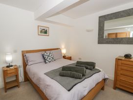 A bedroom with a bed, bedside tables, and a mirror at Awen Ingli in Newport, Pembrokeshire