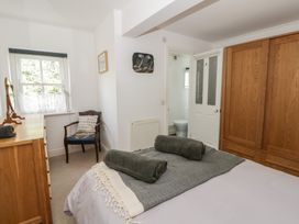 A bedroom with a bed and a chair at Awen Ingli Newport, Pembrokeshire
