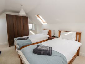 A bedroom with two beds and a wardrobe at Awen Ingli Newport, Pembrokeshire