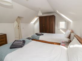 A bedroom with two beds and a wardrobe at Awen Ingli Newport, Pembrokeshire