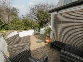 A garden with wicker chairs and a table at Awen Ingli, Newport, Pembrokeshire