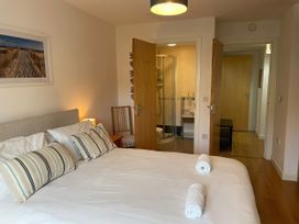 A bedroom with a bed and a bathroom at Broadleys in Swanage