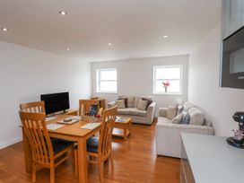 A living room with a dining table and sofa at Sandsend View in Whitby