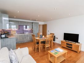 A living room with kitchen area and dining set at Sandsend View in Whitby