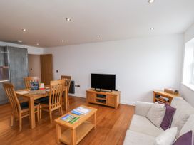 A living room with a sofa and dining area at Sandsend View in Whitby