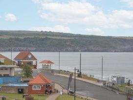 A view of the sea with buildings and benches at Sandsend View in Whitby