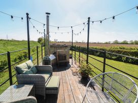An outdoor terrace with seating and a hot tub at Sweet Caroline Shepherd’s Hut Low Marnham near Sutton-On-Trent