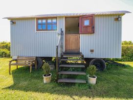 A shepherd's hut with stairs and a bench at Sweet Caroline Shepherd’s Hut in Low Marnham near Sutton-On-Trent