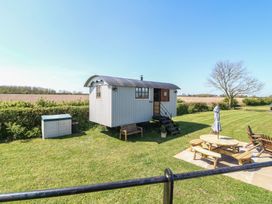 A shepherd's hut with outdoor seating at Sweet Caroline Shepherd’s Hut Low Marnham near Sutton-On-Trent