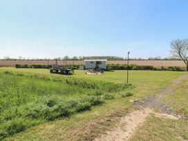 A hut with decking and a lawn at Sweet Caroline Shepherd’s Hut Low Marnham near Sutton-On-Trent