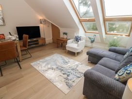 A living room with a television, sofa, and dining table at Upper Deck in Truro