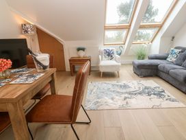 A living room with a sofa and dining table at Upper Deck in Truro